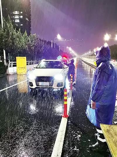 凌晨，東甌大橋卡點(diǎn)處，永嘉縣黨員干部頂風(fēng)冒雨、在嚴(yán)寒中牢牢值守。（　圖片由浙江省溫州市委組織部提供）